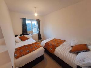 a bedroom with two beds and a window at Exquisite Holiday Home 3 minutes from Dartford Station in Kent
