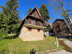 a house with a balcony on the side of it at Vjeverica Chalet in Jahorina
