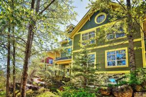 une maison jaune avec une horloge en haut dans l'établissement Tremblant-Les-Eaux C2, à Mont-Tremblant