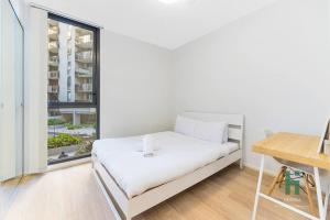 Habitación blanca con cama y ventana en Hurstville Pearl 2 Bedroom Apt, en Sídney