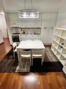 eine Küche mit einem weißen Tisch und weißen Schränken in der Unterkunft Piazza Italia Luxury Apartment in Chianciano Terme