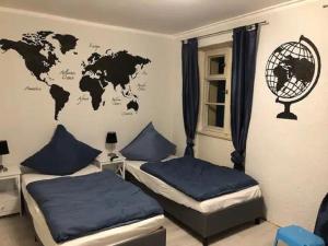 a room with two beds and a world map on the wall at Gästezimmer zur Brücke in Zwiesel