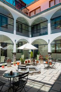 an outdoor patio with tables and chairs and an umbrella at ATOJJA CHUCUITO HOTEL in Puno