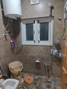 baño con aseo y ventana en Home sleeper en Srinagar