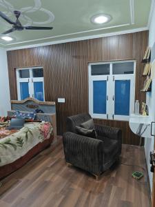 1 dormitorio con 1 cama, 1 sofá y 1 silla en Home sleeper en Srinagar