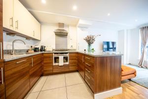 a kitchen with wooden cabinets and a counter top at Apartment by Spitalfields & Liverpool Street Station in London