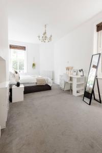a white bedroom with a bed and a mirror at Spacious Apt In Central London in London