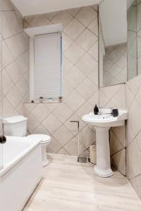 a white bathroom with a sink and a toilet at Spacious Apt In Central London in London
