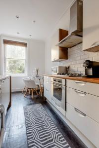 a kitchen with white appliances and a table and a window at Spacious Apt In Central London in London