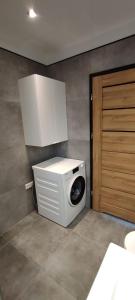 een wasmachine in een kamer met een deur bij Seepark 13a in Goch