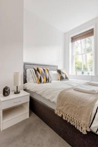 a white bedroom with a large bed and a window at Spacious Apt In Central London in London