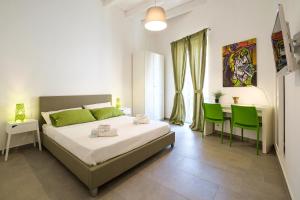 B&B Cala Peppa في باليرمو: غرفة نوم بسرير وطاولة وكراسي