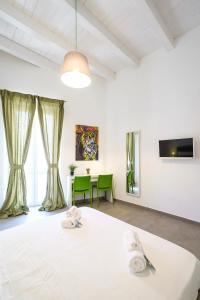 パレルモにあるB&B Cala Peppaの白いベッドとテーブルが備わる客室です。