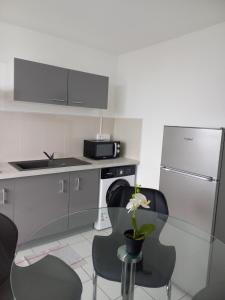 a kitchen with a glass table and a refrigerator at Down town Pointe à Pitre vue mer in Pointe-à-Pitre