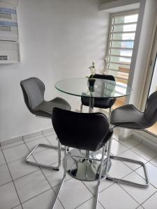 a dining room with a glass table and chairs at Down town Pointe à Pitre vue mer in Pointe-à-Pitre