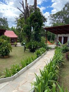 un jardin avec une passerelle, des plantes et un bâtiment dans l'établissement Pousada Fazenda São Bento, à Alto Paraíso de Goiás