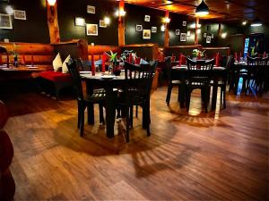 une salle à manger avec des tables et des chaises dans un restaurant dans l'établissement Queenswood Cottage, à Nuwara Eliya