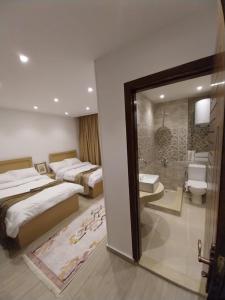 een hotelkamer met 2 bedden en een badkamer bij Zoser Pyramids View- Foreiigners only in Caïro