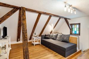 a living room with a black couch and wooden beams at Schwarzwaldtani - Städtle in Bühl