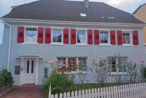 a house with red shutters and a white fence at Schwarzwaldtani - Städtle in Bühl