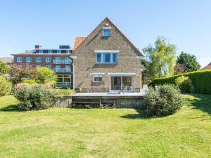 ein Haus mit Rasen vor einem Gebäude in der Unterkunft Villa in St-Idesbald near Ster der Zee Beach in Koksijde