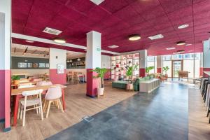 a lobby with purple ceilings and tables and chairs at Student Factory Lyon Parilly in Vénissieux +15 photos