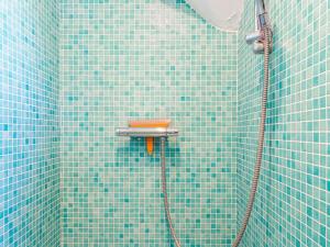 ein blau gefliestes Bad mit einer Dusche mit einem Schlauch in der Unterkunft Villa in St-Idesbald near Ster der Zee Beach in Koksijde