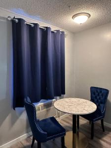 una stanza con tavolo e due sedie e tenda blu di Paxton Inn Motel a Paxton