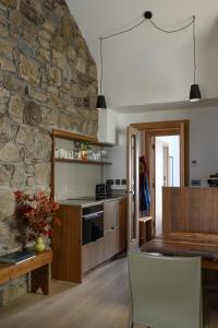 a kitchen with a table and a stone wall at WITHIN THE VILLAGE in Galway