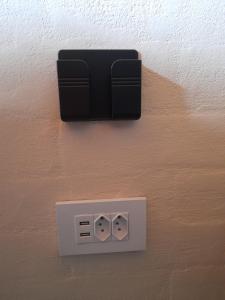 una toma de corriente eléctrica en una pared junto a una pared en Chalé Brisa do Vale, en Santa Luísa de Baixo