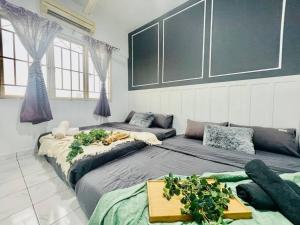 ein Wohnzimmer mit zwei Betten und einer Couch in der Unterkunft 8 pax Homestay near Axiata Arena & Pavilion 2 in Kuala Lumpur