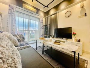 Schlafzimmer mit einem Bett, einem TV und einem Schreibtisch in der Unterkunft 8 pax Homestay near Axiata Arena & Pavilion 2 in Kuala Lumpur