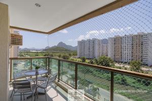 een balkon met een tafel en stoelen en een aantal gebouwen bij TOP 3 QUARTOS com ESTACIONAMENTO em Condominio com PORTARIA 24h, PISCINA, Sauna e Parquinho Infantil - Apartamento com Ar Condicionado, SmarTV, Wi-Fi 120 mbps e Cozinha Completa in Rio de Janeiro