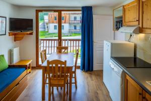 a kitchen and dining room with a table and chairs at Noemys Chalets de Bois Méan in Les Orres