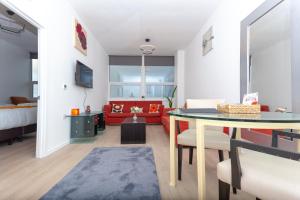 a living room with a table and a red couch at One Bedroom apartment Serviced apartment Smethwick flat 315 in Birmingham