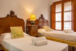 ein Schlafzimmer mit 2 Betten und einer Lampe auf einem Tisch in der Unterkunft Santa Cruz Refinadores Suite by Valcambre in Sevilla