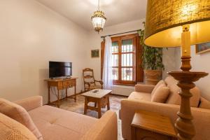 ein Wohnzimmer mit einem Sofa und einem Tisch in der Unterkunft Santa Cruz Refinadores Suite by Valcambre in Sevilla