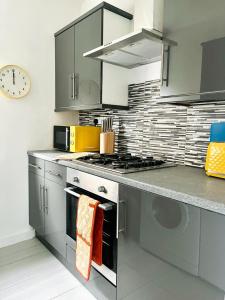 a kitchen with stainless steel appliances and a clock on the wall at Clyde 52 in Glasgow