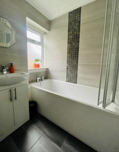 Baño blanco con bañera y lavamanos en Clyde 52, en Glasgow