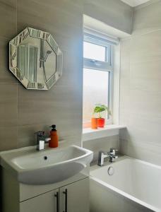 a white bathroom with a sink and a mirror at Clyde 52 in Glasgow