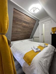 a bedroom with a large bed with towels on it at Cabana Green Hill in Borşa