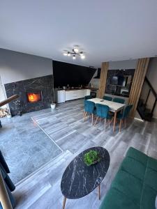 a living room with a table and a fireplace at Cabana Green Hill in Borşa