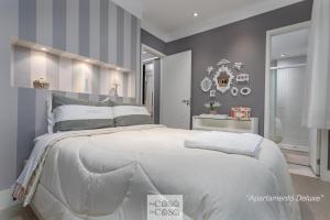 a bedroom with a large white bed with gray walls at 2 Apartamentos Individuais de 3 QUARTOS com ESTACIONAMENTO em Condomínio com PORTARIA 24h, Sauna e Parquinho Infantil - Apartamento com Ar Condicionado, SmarTV, Wi-Fi 120 mbps e Cozinha Completa in Rio de Janeiro +37 photos