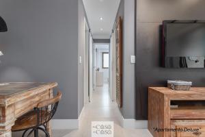 a hallway with a table and a television on a wall at 2 Apartamentos Individuais de 3 QUARTOS com ESTACIONAMENTO em Condomínio com PORTARIA 24h, Sauna e Parquinho Infantil - Apartamento com Ar Condicionado, SmarTV, Wi-Fi 120 mbps e Cozinha Completa in Rio de Janeiro