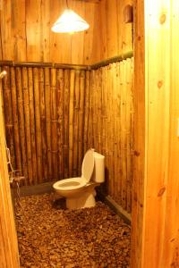 a bathroom with a toilet in a wooden wall at Sultan Resort Syariah in Payakumbuh