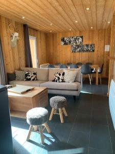 a living room with a couch and two stools at Chalet Barcelonnette in Barcelonnette