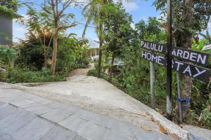 ラブハン・バジョにあるPalulu Garden Homestayの庭園の家を読む看板のある道