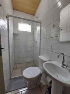 y baño con aseo y lavamanos. en Casa Ribeirão da Ilha AEROPORTO, en Florianópolis
