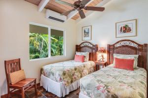 1 dormitorio con 2 camas y ventana en Kona Beach Bungalows, en Kailua-Kona