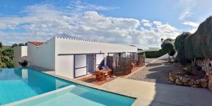 uma villa com uma piscina ao lado de uma casa em Apartamento Binibeca Nou Cami de Cavalls em Binibeca